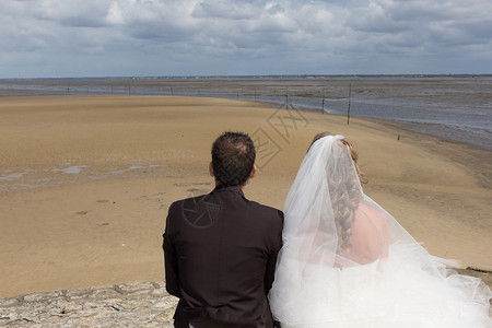 美丽的情侣在沙滩上穿着婚纱图片