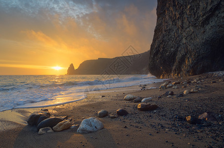 海景与日落晚上在海边海岸上美丽的岩图片