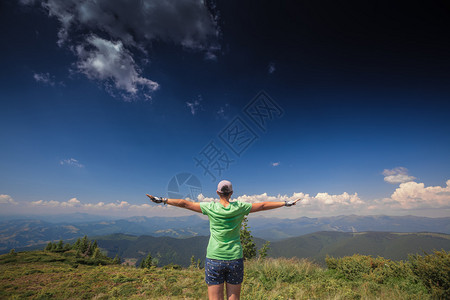 站在山顶上张开双臂的女人图片