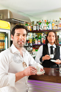 咖啡店咖啡师和一位客户在咖啡馆里喝咖啡背景图片