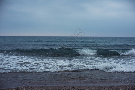 海浪冲刷着沙滩摄影图 深蓝色大海与天空连成一线图片