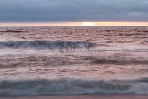 太阳在地平线下落日浓密的雾库典型的加利福尼亚海岸和波图片