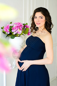 身着深蓝色礼服的年轻漂亮孕妇背景图片