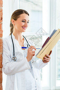 青年女医生站在诊所窗口的年轻女医生图片