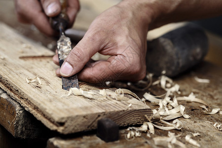在木制工作台上用锯子和雕刻工具操作木制图片