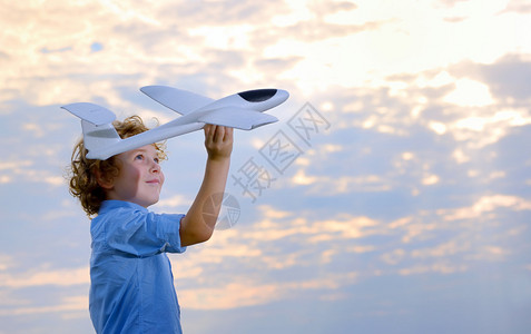 男孩在田野里扔飞机图片