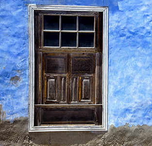 蓝色墙壁中的棕色木窗西图片