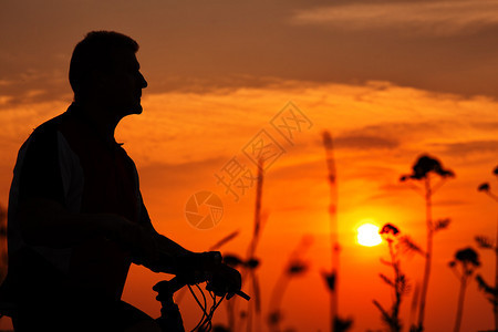 日落一个骑摩登自行车的男人背景图片