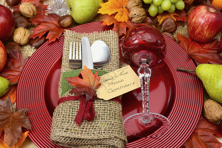 果实的感恩节里有卷饼包裹餐具红晶葡萄酒杯在大充电器板上还有秋天收图片