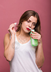 女人用乳液和化妆棉清洁她的脸图片