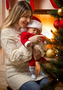 在圣诞树装饰的圣诞老人服装中快乐的图片