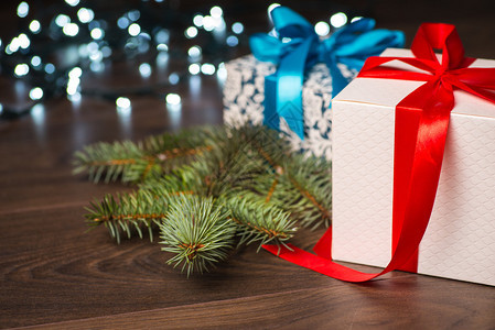圣诞礼物盒上面有红蓝弓和木板表面的b图片