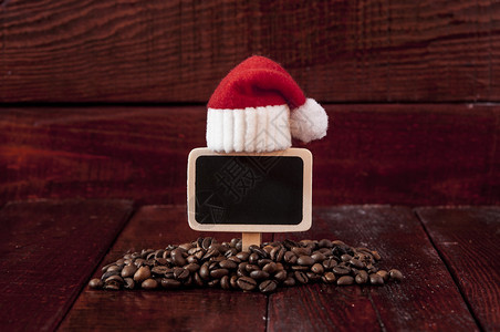 圣诞咖啡豆和木桌上的空白黑板图片
