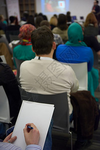 年轻商人在教育培训会议研讨会上做笔记图片