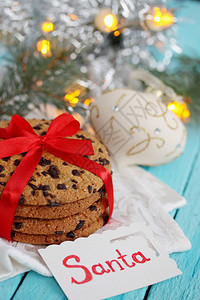 巧克力饼干绑了红丝带礼物在木制背景上圣诞背景和复制空图片