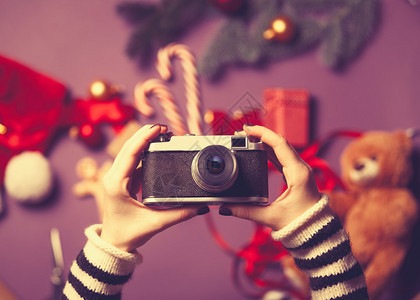 持有圣诞节礼物照相机的妇女在圣诞图片