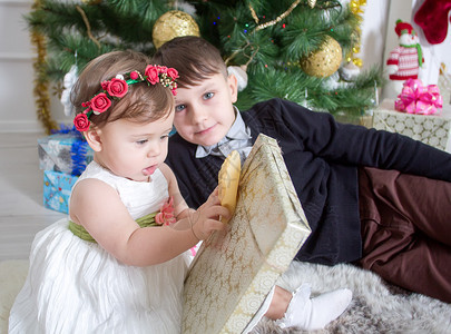 圣诞树旁的男孩和女孩图片