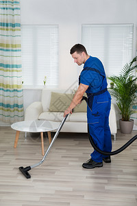 工人清洁地板和家里吸尘器清洁工的图片