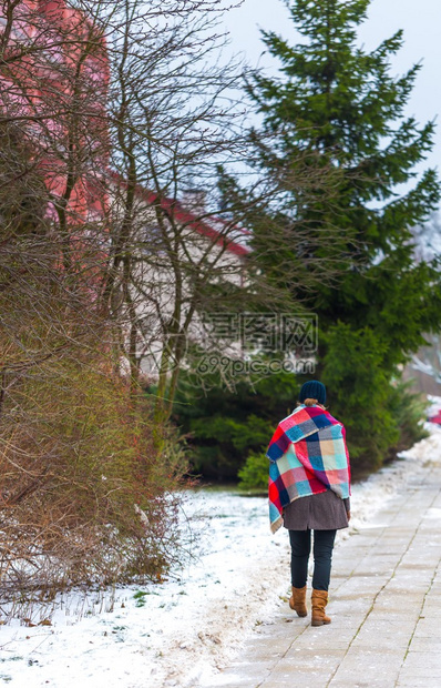 女孩在冬天走人行道身着温暖衣服和图片