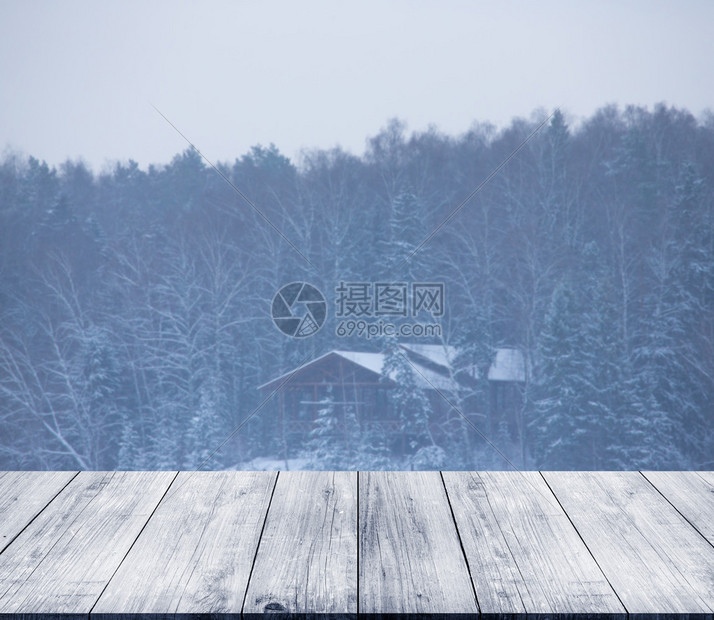 在寒雪的冬季中从黑暗的木质车道桌子或桥上看图片