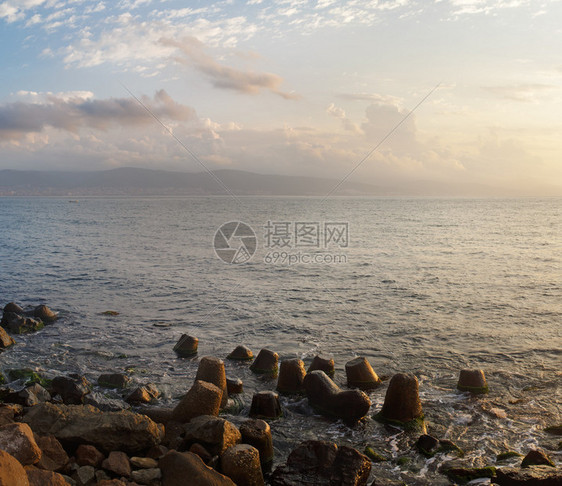 早上的海景平静的大海多云的天空和地平线上的山脉前景中图片