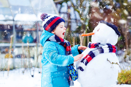 有趣的小男孩堆雪人图片