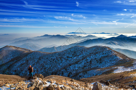 年轻女子徒步旅行者与摄影机拍照在山图片