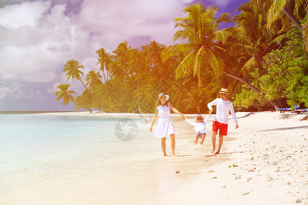 带着孩子在热带沙滩上玩耍的家庭图片