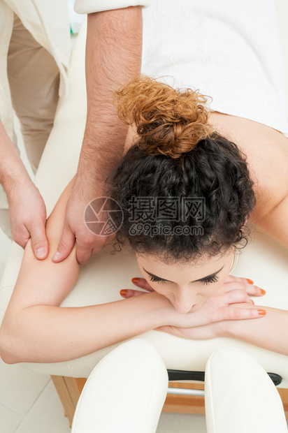 年轻妇女在温泉中心接受对肩部图片