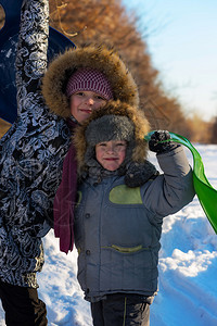 男孩和女孩都很高兴冬天的好天气孩子们在冬天的森林图片