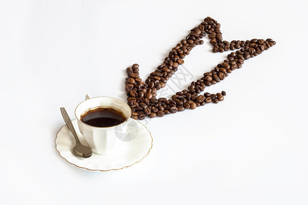 箭头由咖啡豆和一杯咖啡用勺子制成隔离图片