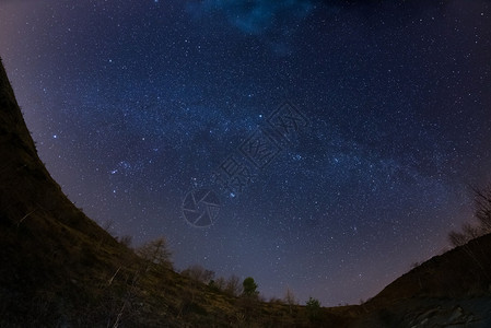 星空和银河系在阿尔卑斯山脉上通过鱼眼镜头捕捉图片