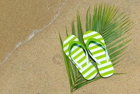 沙滩上的一双绿色条纹凉鞋图片