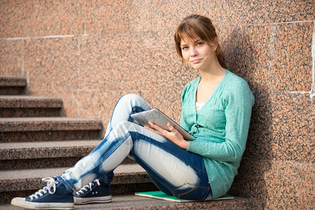 准备户外考试美丽的年轻女学生从记事本上写或读一些东西女人坐在城市图片