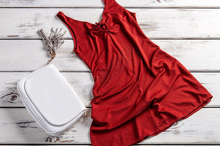 红色连衣裙和皮革钱包架子上有衣服的手提包优雅的晚礼服和配饰图片