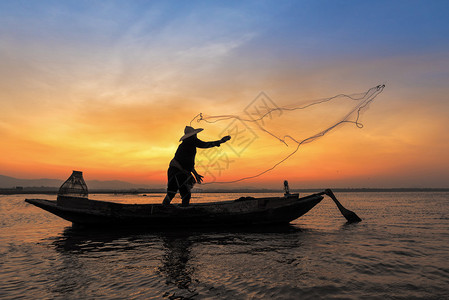 木船在行动扔在自然河在清晨日出前淡水捕鱼网亚洲渔民的剪影图片