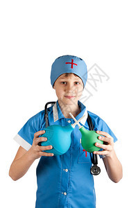 穿蓝白色医生服装的年轻男孩带着听诊器手持蓝色和绿色灌肠图片