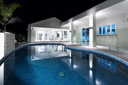 现代旅馆或夜间房屋的蓝水环泳池灯光图片