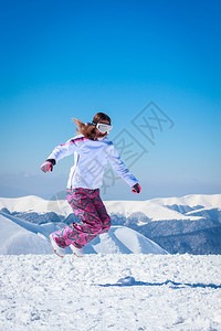 跳跃在雪山的美丽的女孩图片