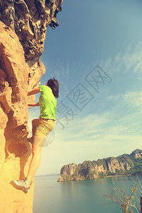 女子攀岩者在海边攀登图片