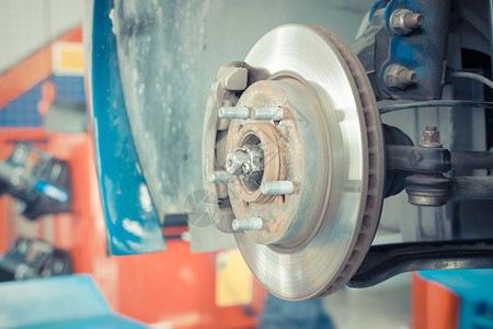 车库停机维修的轮式中转器和汽车磁盘刹车图片