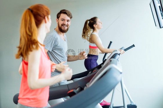 人们在健身房穿体操各种机器作为心血管图片