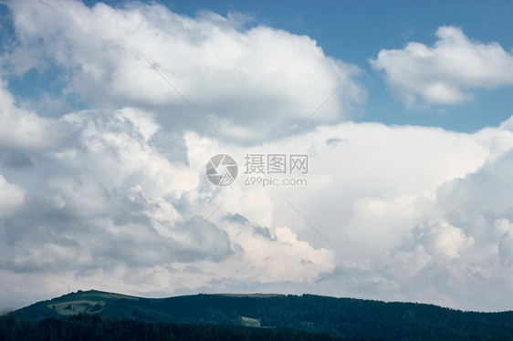 在蓝天空和云雾的本底山丘和山谷的美丽图片