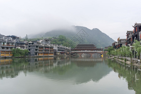 凤凰古镇远处的早雾中天亮时雾笼罩着大江河背景