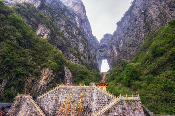 一座大水侵蚀了两座山峰之间的洞穴在Chiangjiajie的锡亚门山图片