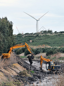 大型挖掘机从泥土和废墟中清理河流的河床图片