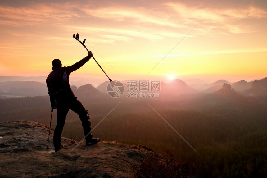 快乐的人在防盗器和头顶上的药杆断腿保持高峰打开迷雾笼罩的山谷波纹悬崖游客用手在空气中的剪影图片