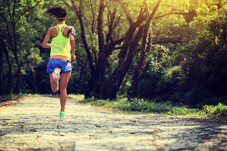 跑在森林里的年轻健身女子越野跑者图片