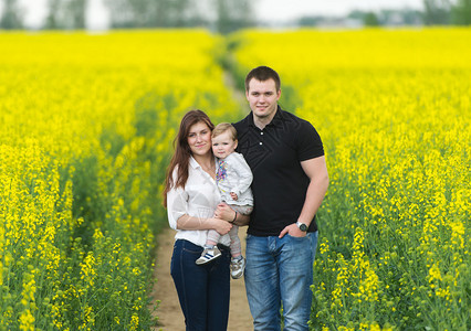 父母和宝在黄色的油菜花田里休息图片