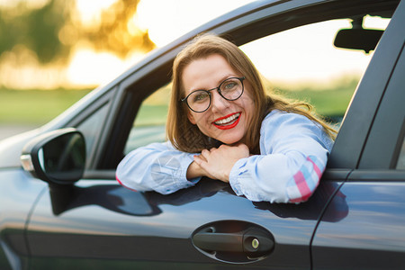 坐在车里的年轻快乐女人购买二手车图片
